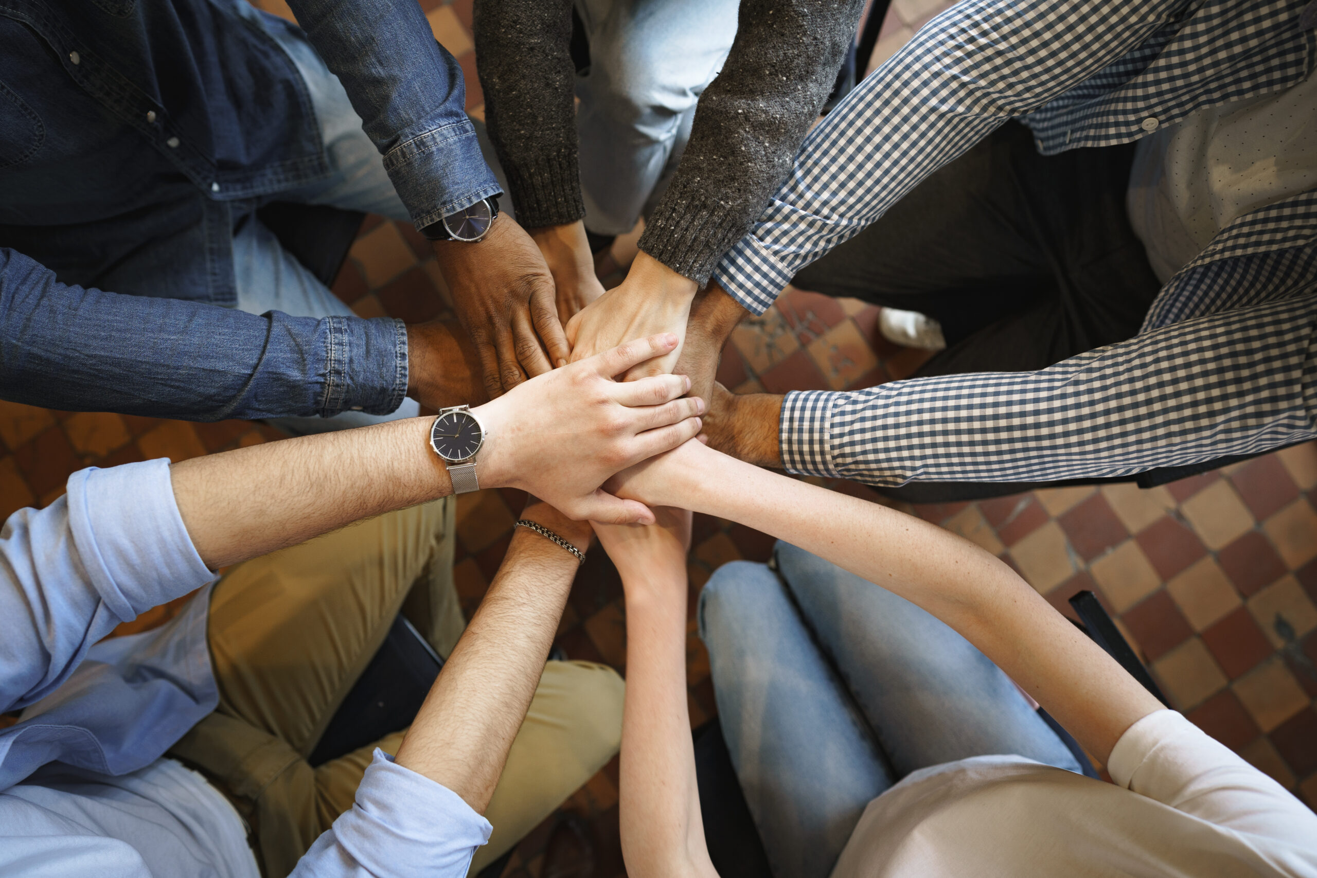 Top view of diverse people hands holding together in circle, hands stack